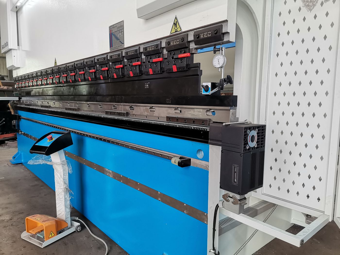 Close-up of press brake ram with segmented tooling clamps
